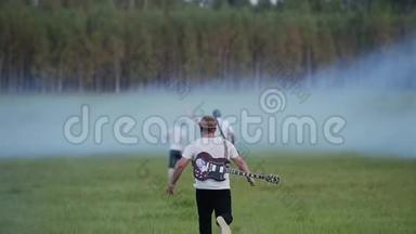 摇滚乐队的音乐家跑到烟雾弥漫的一大片田野。 他们`只是玩玩而已。 好心情